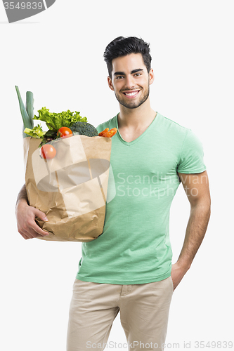 Image of Man carrying a bag full of vegetables