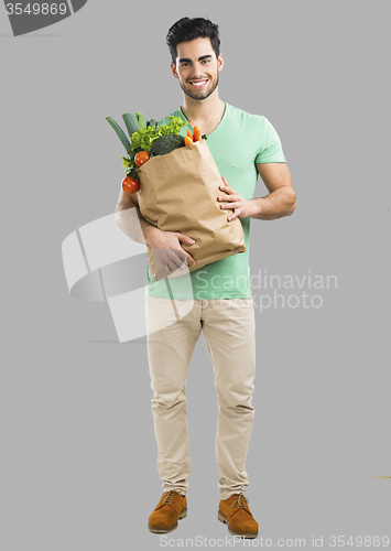 Image of Man carrying a bag full of vegetables