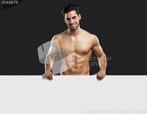 Image of Sexy young man holding a cardboard
