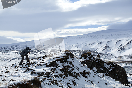 Image of Photographer in wintry mountain landscape, Iceland