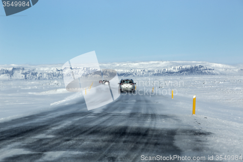 Image of Snowy and icy road with volcanic mountains in wintertime