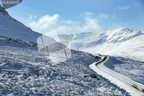 Image of Snowy and icy road with volcanic mountains in wintertime