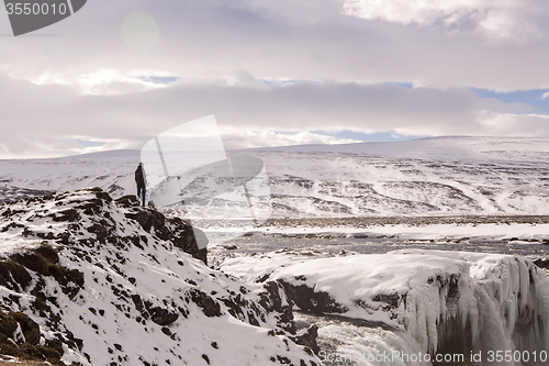 Image of Hiker at mountain top of waterfall Godafoss