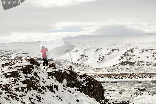 Image of Hiker at mountain top of waterfall Godafoss