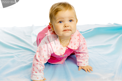 Image of baby girl in a dress crawling