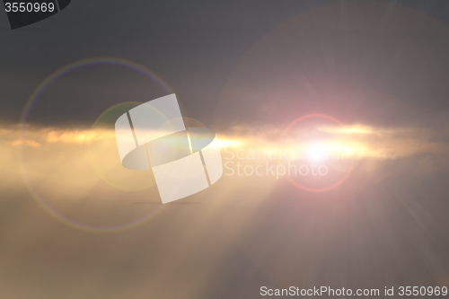 Image of sun shinning from behind the clouds