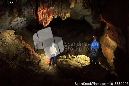 Image of speleologists in lightened cave