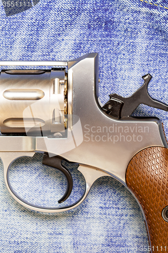 Image of Nagan revolver on blue jeans background