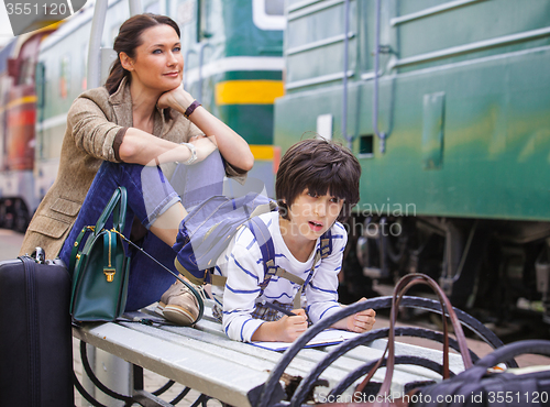 Image of Mother and son waiting for a train