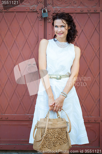 Image of Smiling beautiful middle-aged woman in a white dress