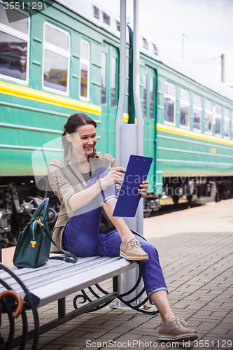 Image of woman takes notes in notepad and laughing