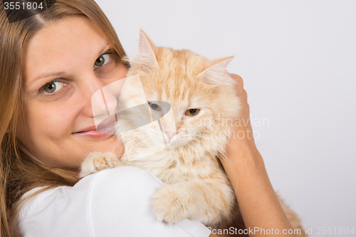 Image of Girl hugging a disgruntled cat