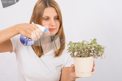 Image of Girl watering a flower from the sprinkler Home