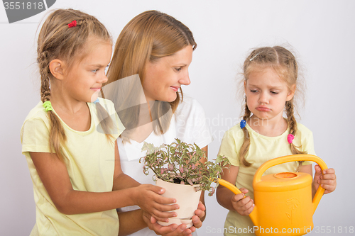 Image of One daughter was mad at my mom and another daughter watering flowers