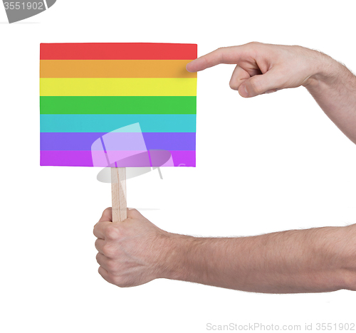 Image of Hand holding small card - Flag of Rainbow flag