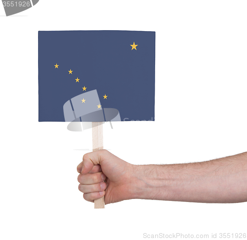 Image of Hand holding small card - Flag of Alaska