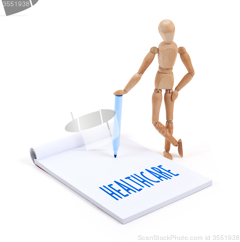 Image of Wooden mannequin writing - Healthcare