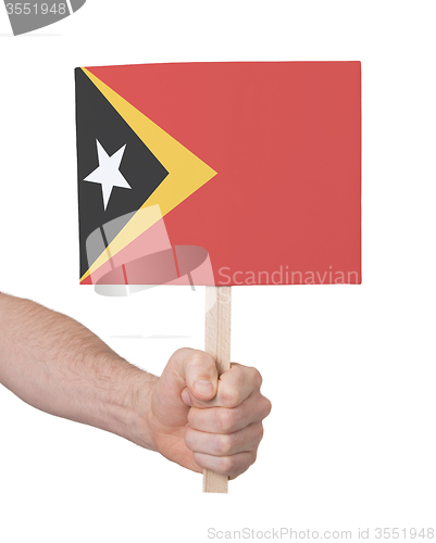 Image of Hand holding small card - Flag of East Timor