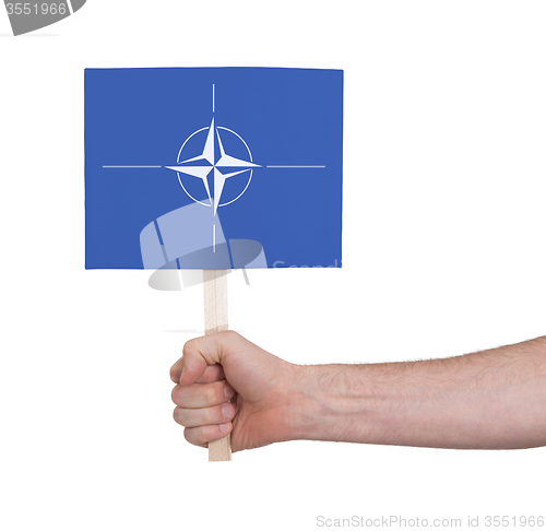 Image of Hand holding small card - Flag of NATO