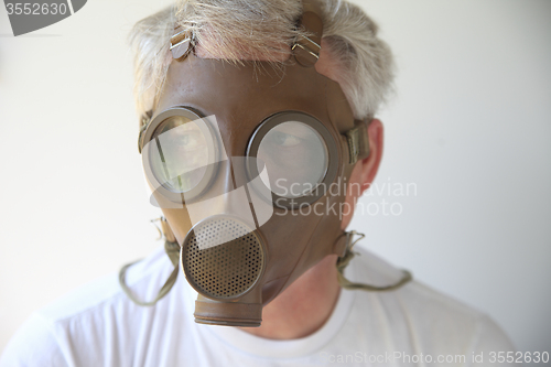 Image of old gas mask worn by senior man 