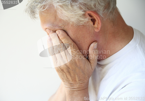 Image of older man overcome with depression or emotions 