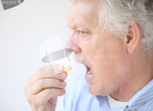 Image of senior takes fish oil supplement 