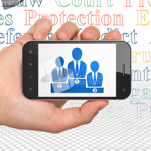 Image of Law concept: Hand Holding Smartphone with Business Team on display