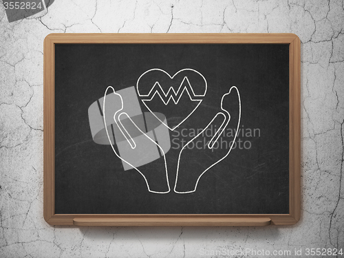 Image of Insurance concept: Heart And Palm on chalkboard background