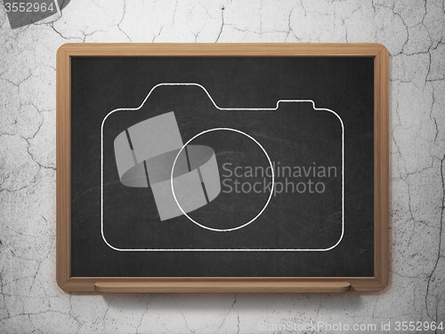 Image of Vacation concept: Photo Camera on chalkboard background