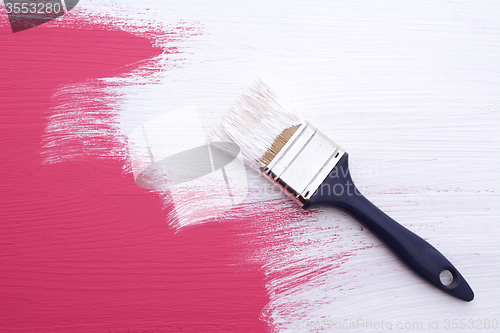 Image of Covering pink paint with a coat of white emulsion