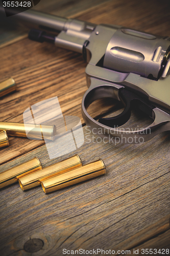 Image of Nagan revolver with cartridges on wood boards