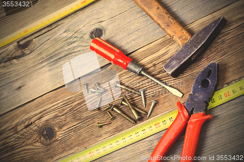 Image of Old hammer, pliers, yellow measuring tape, vintage screwdriver a