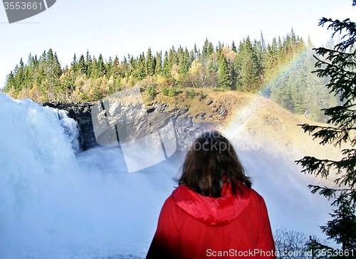 Image of Woman by a foaming waterfall