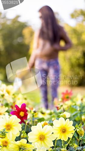 Image of Beautiful long haired woman and many flowers