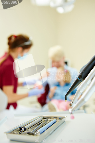 Image of Pediatric dentist explaining to young patient and her mother the model