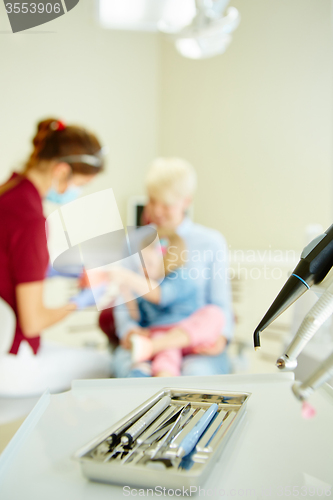 Image of Pediatric dentist explaining to young patient and her mother the model