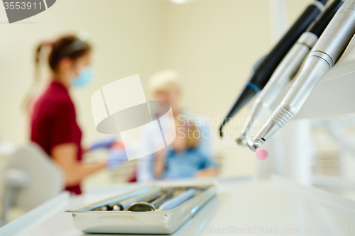 Image of Pediatric dentist explaining to young patient and her mother the model