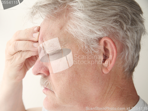 Image of man with headache over eye