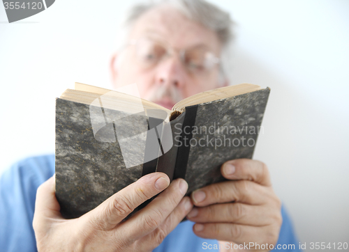 Image of older man reads book 