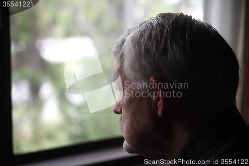 Image of sad senior by a window