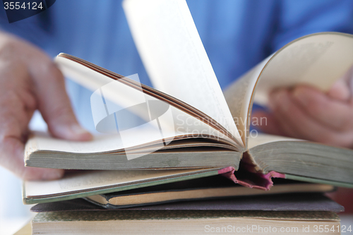 Image of Man looks at a book. 