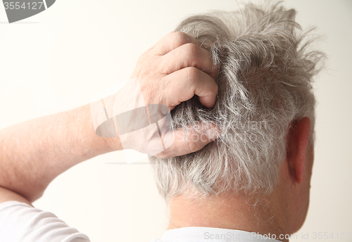 Image of senior man scratching head 