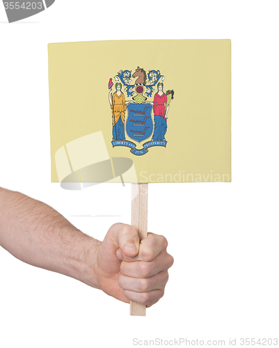 Image of Hand holding small card - Flag of New Jersey