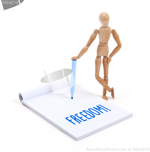 Image of Wooden mannequin writing - Freedom