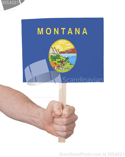 Image of Hand holding small card - Flag of Montana