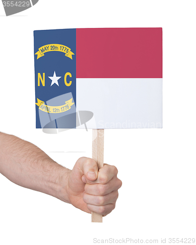 Image of Hand holding small card - Flag of North Carolina