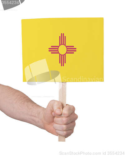 Image of Hand holding small card - Flag of New Mexico