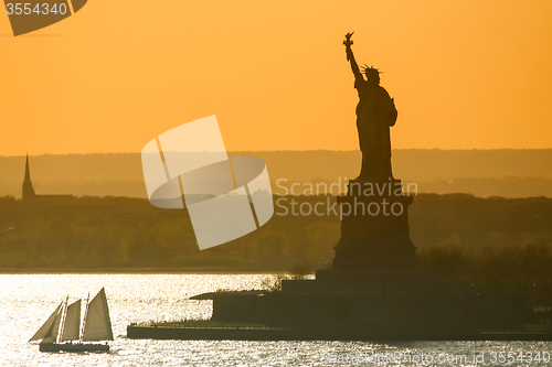 Image of Boat sailing next to Statue of Liberty