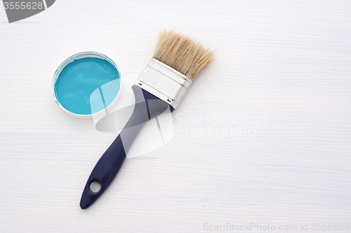 Image of Clean paintbrush and blue paint on white board