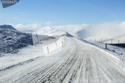 Image of Snowy and icy road with volcanic mountains in wintertime